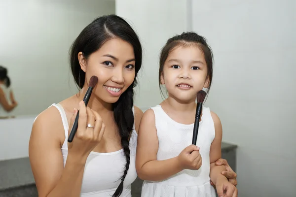 Mother and daughter applying make up — Stock Photo, Image