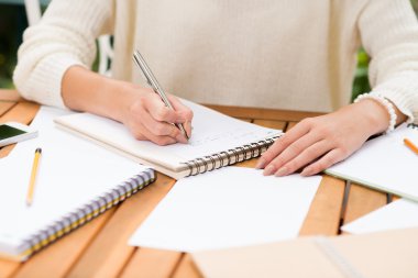 woman making notes in her notepad clipart