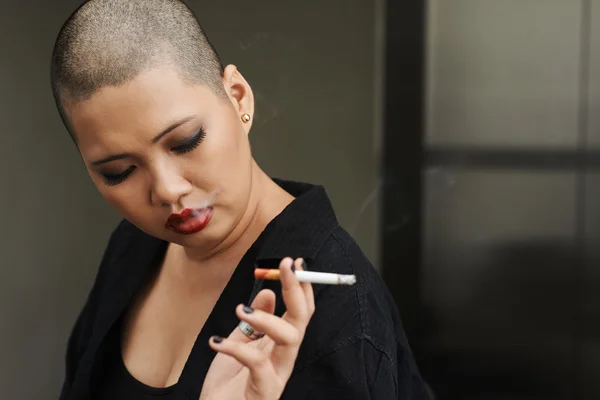 Mujer con peinado afeitado fumar cigarrillo — Foto de Stock