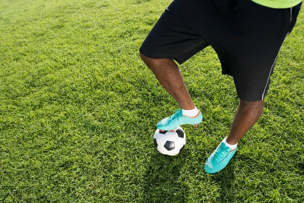 Футболист с мячом на поле — стоковое фото