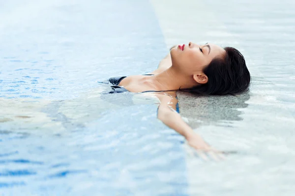 Mulher asiática relaxante na piscina — Fotografia de Stock