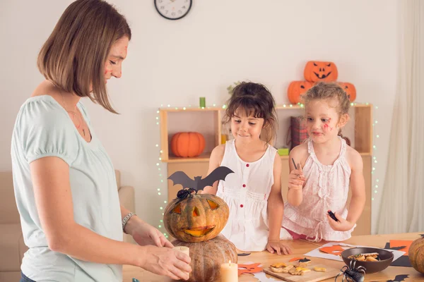 Madre e hijas decorando calabazas — Foto de Stock