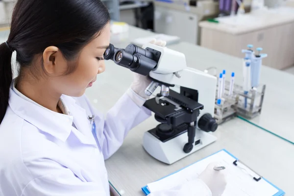 Ricercatrice scientifica femminile al microscopio — Foto Stock