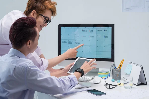 Colegas llenando calendario de negocios — Foto de Stock