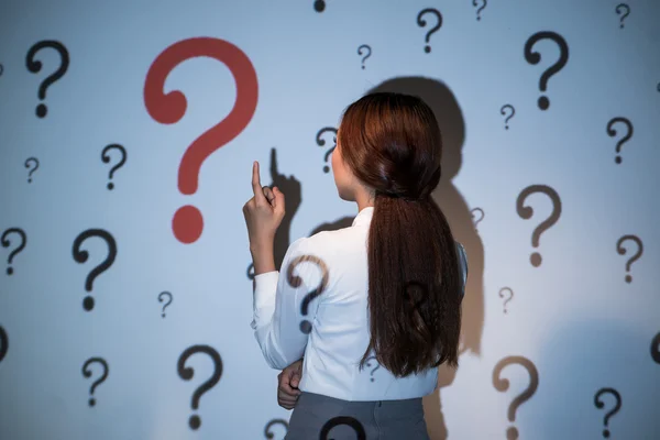 Donna guardando il muro con punti interrogativi — Foto Stock