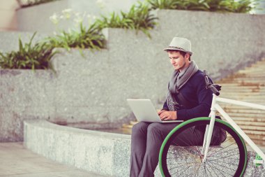 Dizüstü bilgisayarda çalışan genç adam.