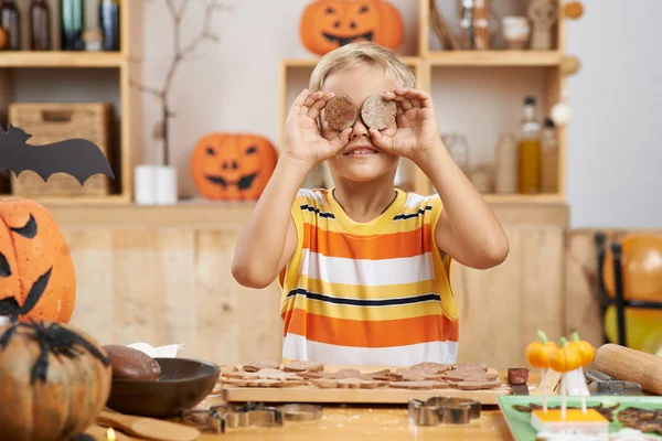 Funny boy covering eyes with cookies — Stock Photo, Image