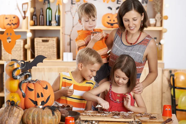 Mother and children glazing cookies — Stock Photo, Image