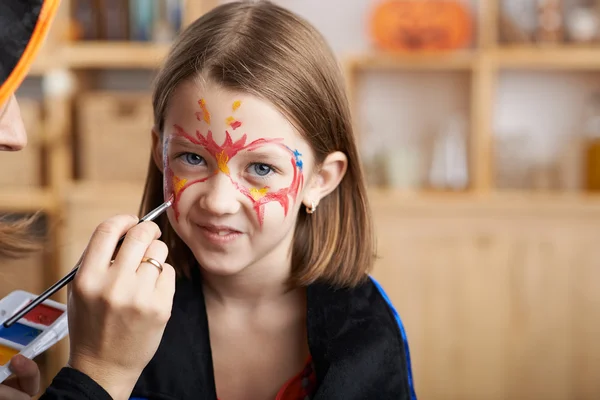 Smiling girl having face painted — Stock Photo, Image