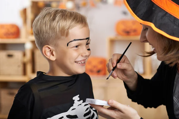 Madre pintando la cara de su hijo — Foto de Stock