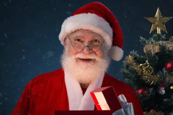 Cheerful Santa with Christmas present — Stock Photo, Image