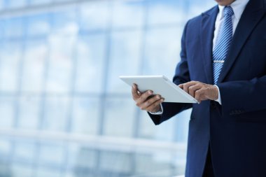 Dijital tablet üzerinde çalışan iş adamı