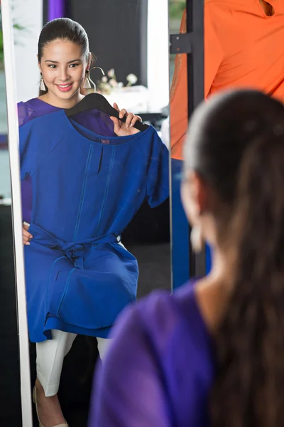 Vackra leende kvinna försöker på klänning — Stockfoto