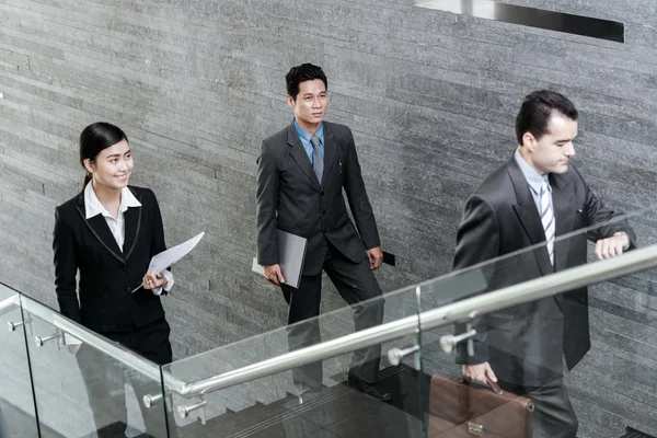 Asian business people walking up stairs — Stock Photo, Image