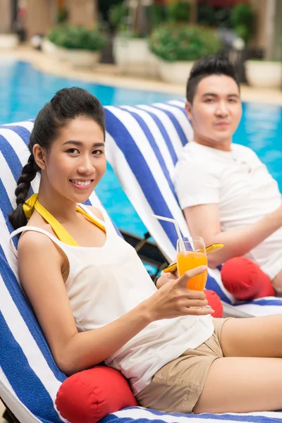 Paar ontspannen bij zwembad — Stockfoto