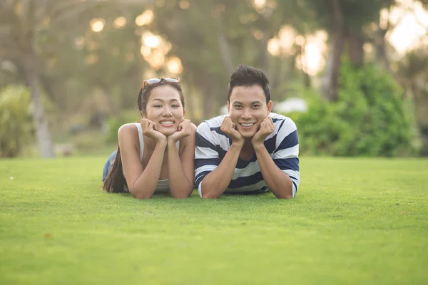 Heureux couple vietnamien allongé sur l'herbe — Photo