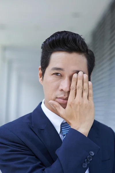 Businessman with hand on face — Stock Photo, Image