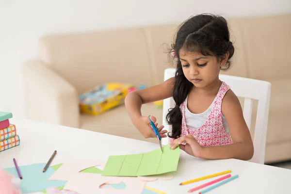 Menina cortando papel — Fotografia de Stock