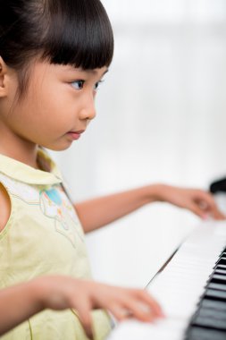 Asian girl playing piano clipart