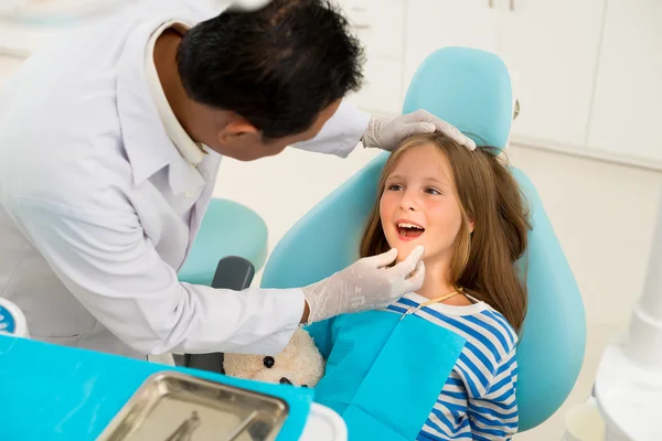 Dentist examining teeth of little girl — Stock Photo, Image