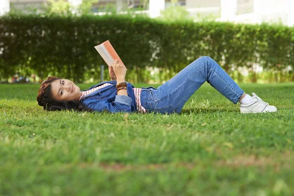 Aziatische student liggen met boek — Stockfoto