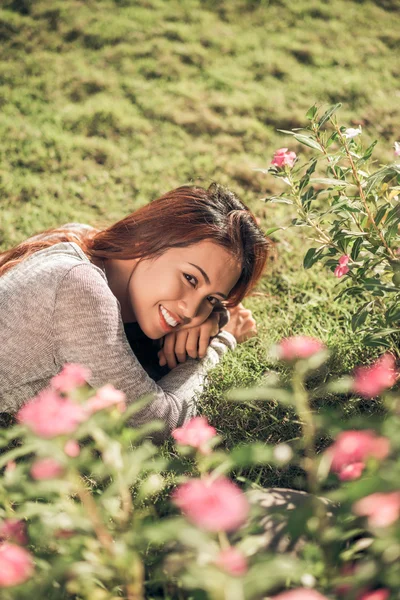 Usmívající se žena ležící na trávě — Stock fotografie