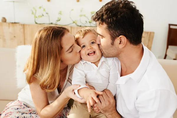 Föräldrar kyssa deras lille son — Stockfoto