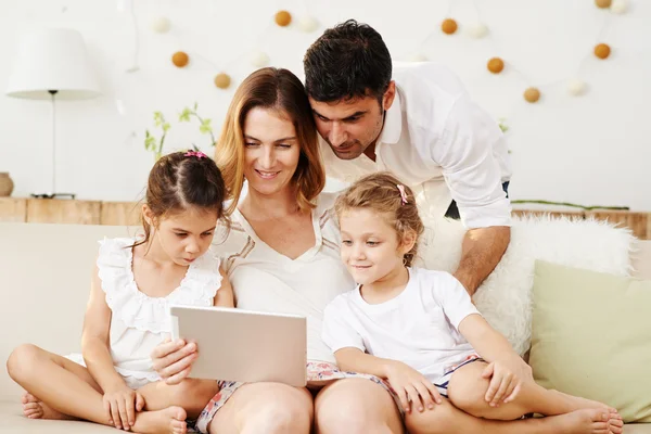 Ouders en twee dochters kijken naar film — Stockfoto