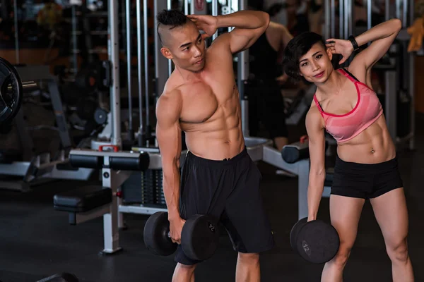 Pareja haciendo dumbbell lado curvas —  Fotos de Stock