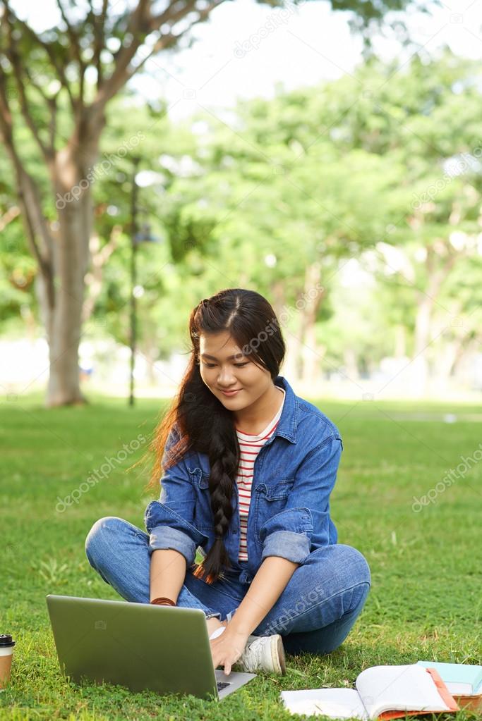 Vietnamese college girl typing on laptop