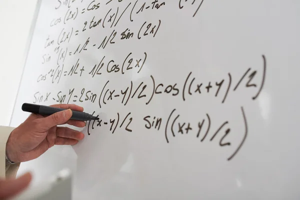 Male hand writing math equations