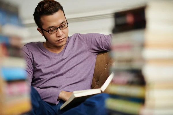 Estudante universitário leitura na biblioteca — Fotografia de Stock