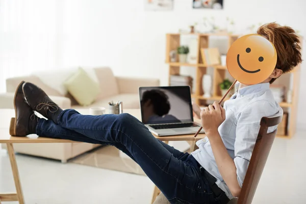 Freelancer segurando emoji ligeiramente sorridente — Fotografia de Stock