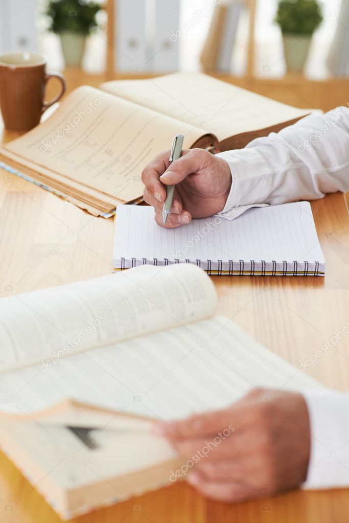 Man reading writing in his textbook