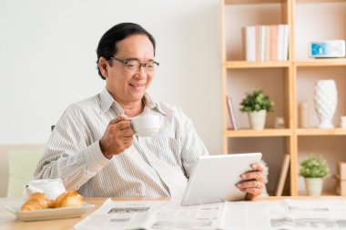 Kahve içme ve haber okumak adam