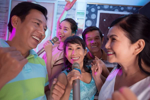 Les gens dansent et chantent au karaoké — Photo