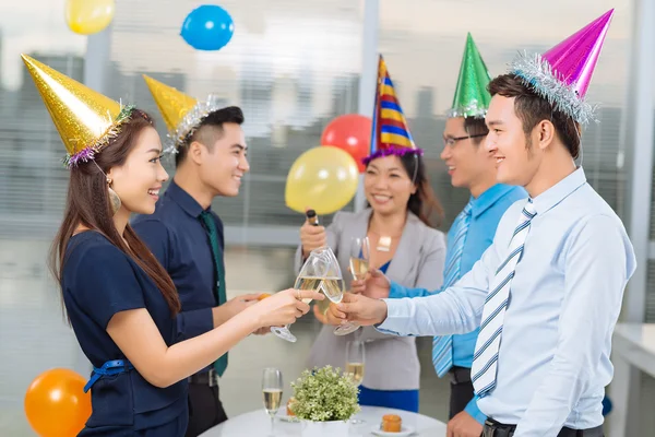 Коллеги звенят в очках на офисной вечеринке — стоковое фото