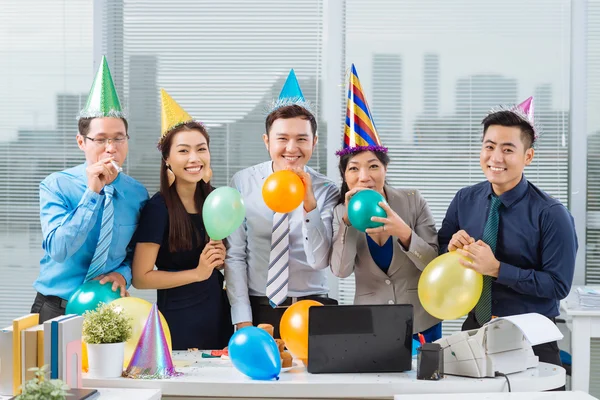 Business team blowing up balloons