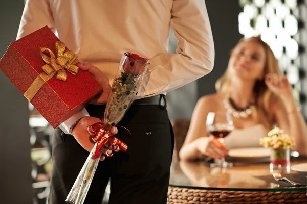 Mann versteckt rote Rose und Geschenk — Stockfoto