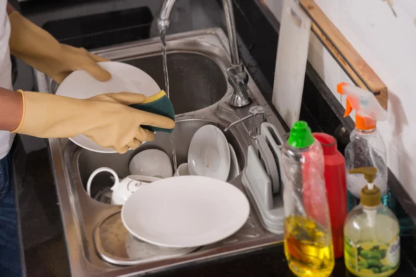 Handen van persoon wassen platen — Stockfoto