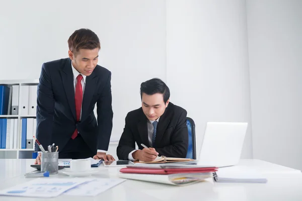 Empresarios vietnamitas trabajando en informe — Foto de Stock