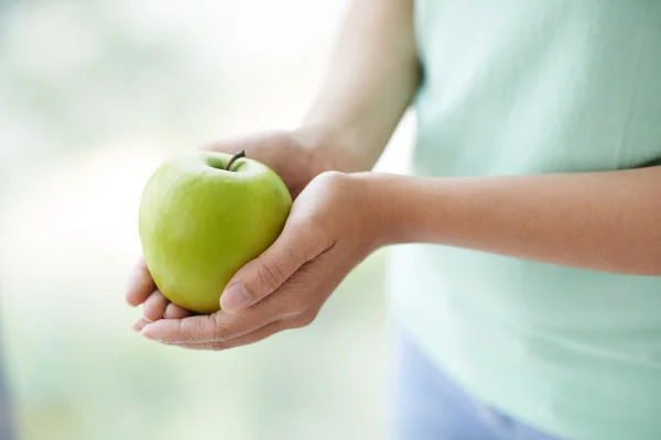 Green apple in female hands — Stock Photo, Image