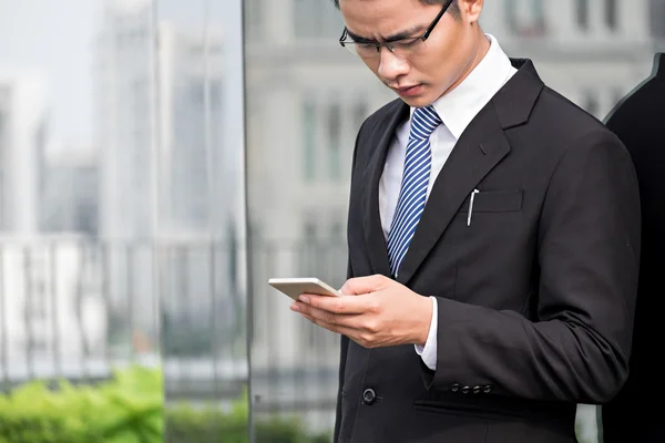 Läser textmeddelande på sin smartphone — Stockfoto