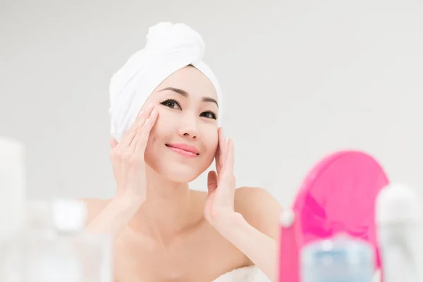 Mujer aplicando crema hidratante — Foto de Stock