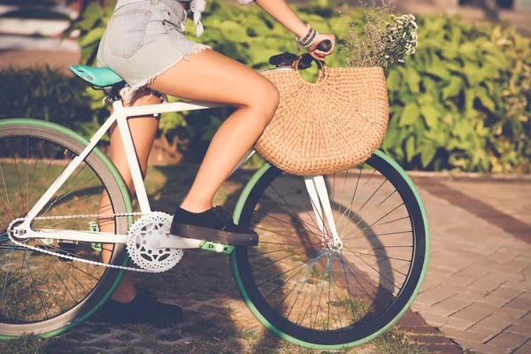 Menina em calções jeans andar de bicicleta — Fotografia de Stock