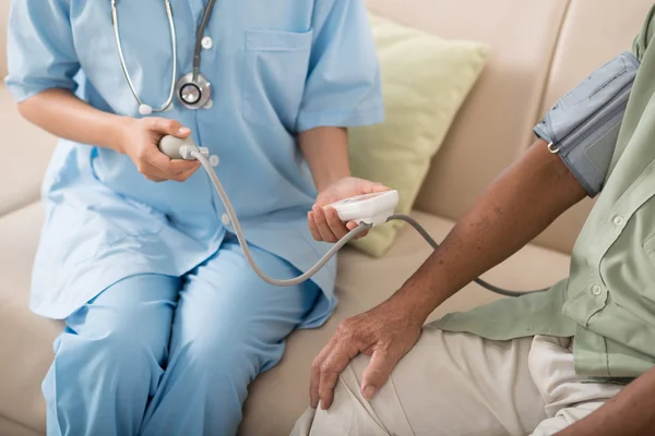 Läkare använder elektronisk blodtrycksmätare — Stockfoto