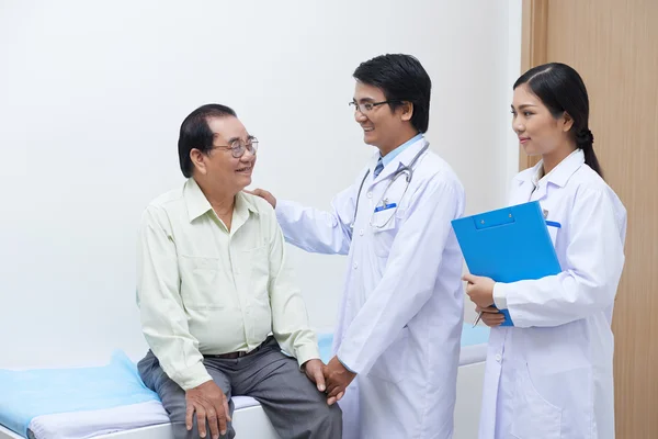 Médico asiático alentador paciente — Foto de Stock