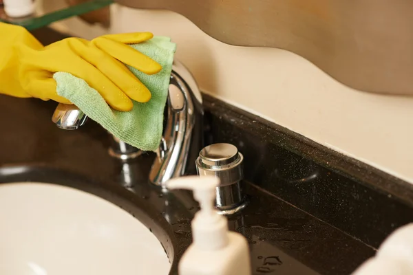 Wiping kitchen faucet — Stock Photo, Image