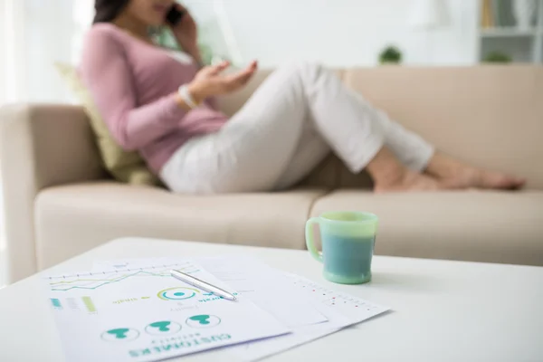 Coffee on table and business lady in background — Stock Photo, Image