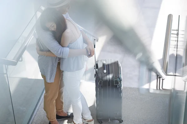 Asiatisches Mädchen umarmt ihren Freund im Flughafen — Stockfoto
